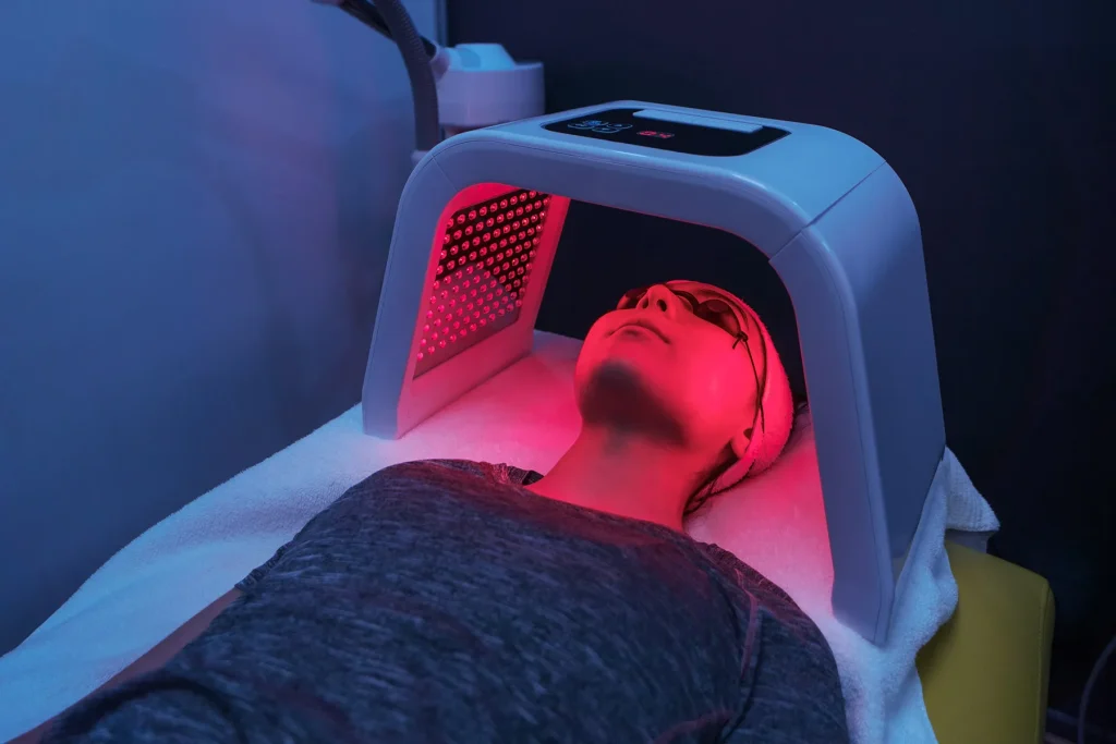 Client lying under a red light panel